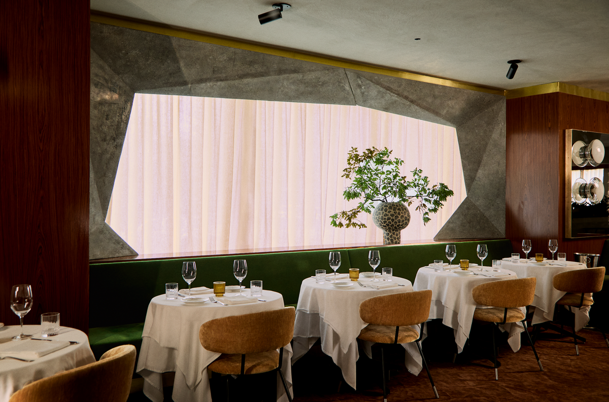 a table set for dinner in a room with a vase of flowers
