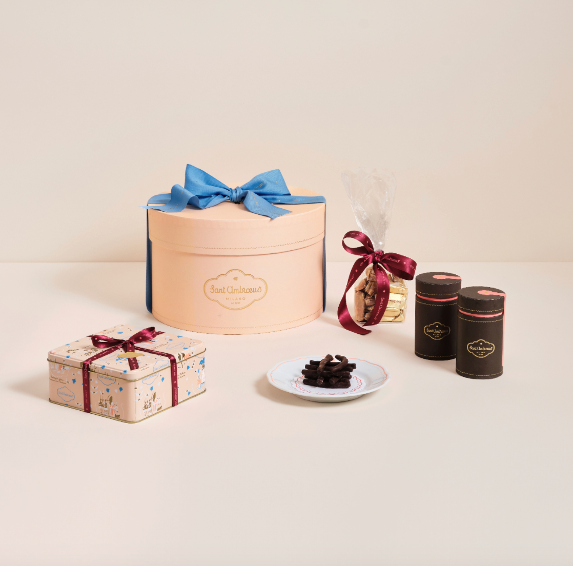 a group of boxes with a bow and a plate of chocolate